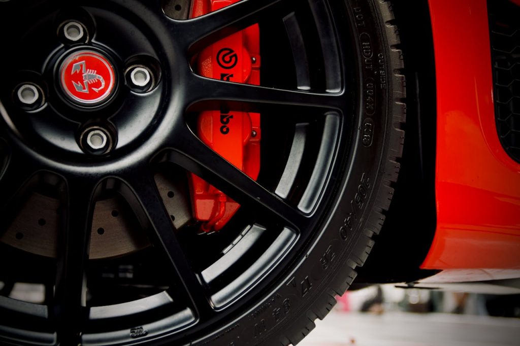 Detailed view of a black wheel and red Brembo brake on a sports car.